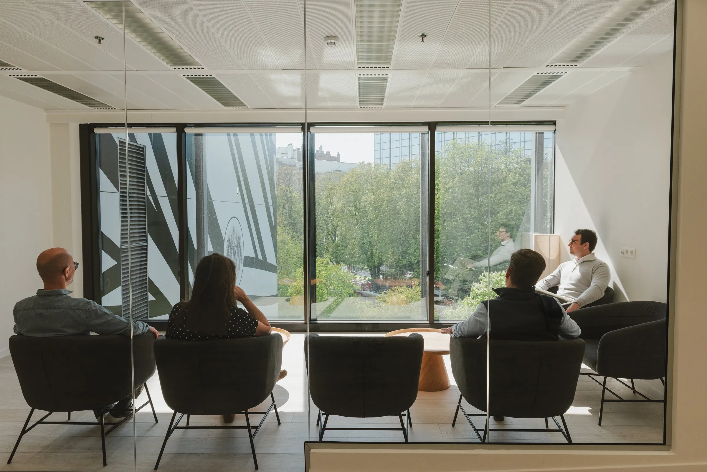 Patients waiting in armchairs facing the window